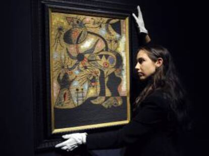 Una empleada de la casa de subastas Christie's junto al cuadro "'L'échelle de L'evasion" del artista Joan Miró. EFE/Archivo