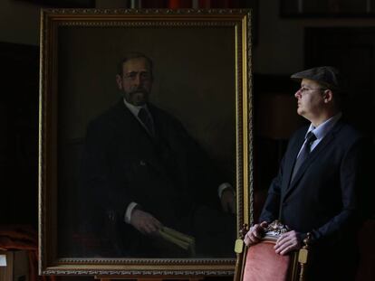El pintor Alejandro Cabeza junto al &uacute;ltimo retrato que ha pintado, el del ge&oacute;logo Lucas Mallada, en el Museo Geominero de Madrid.
 