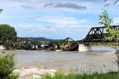 Several train cars are immersed in the Yellowstone River after a bridge collapse near Columbus, Mont., on Saturday, June 24, 2023.