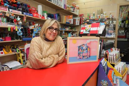 Cristina Herrero en su negocio, la papelería Mashe, con el cartel.