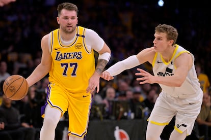 Luka  Doncic conduce el balón frente a Lauri Markkanen en su primer juego para los Lakers .