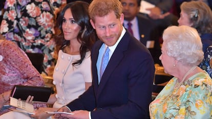 Isabel II, Enrique de Inglaterra y Meghan Markle, en una entrega de premios en el palacio de Buckingham en junio de 2018.
