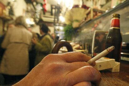 Una persona fuma en un bar de Sevilla.