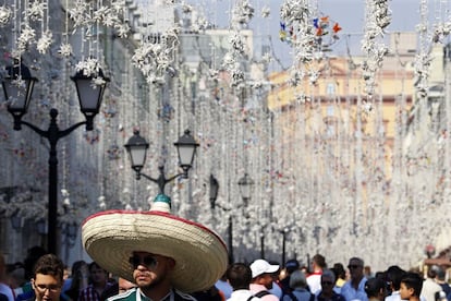 Un aficionado al fútbol usa un sombrero mexicano mientras camina por la calle Nikolskaya en el centro de Moscú, Rusia.