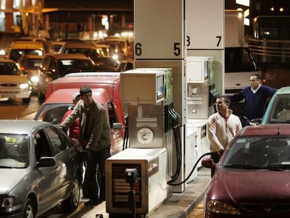 Drivers line up to fill their tanks at a gas station.