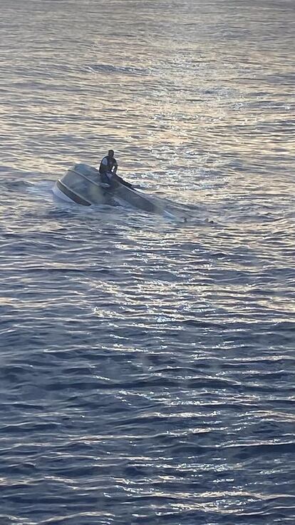 Fotografía divulgada por la sección Sureste de la Guardia Costera estadounidense donde se aprecia a un sobreviviente de un naufragio aferrado en un bote frente de la costa de Fort Pierce, a unos 240 kilómetros (150 millas) al norte de Miami, Florida (EE. UU).  