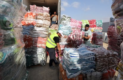 Voluntarios egipcios descargan mantas destinadas a los palestinos de la franja de Gaza, el martes en el cruce fronterizo de Rafah. 