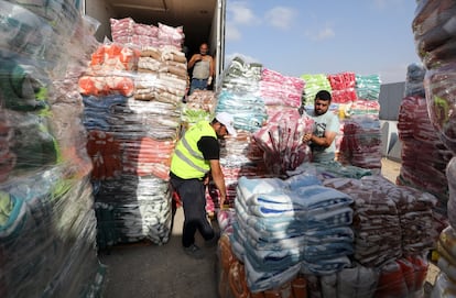 Voluntarios egipcios descargan mantas destinadas a los palestinos de la franja de Gaza, el martes en el cruce fronterizo de Rafah.