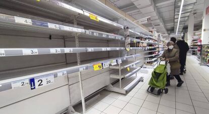  Una mujer observa unas estanterías vacías de legumbres en un supermercado de Madrid. Efe 