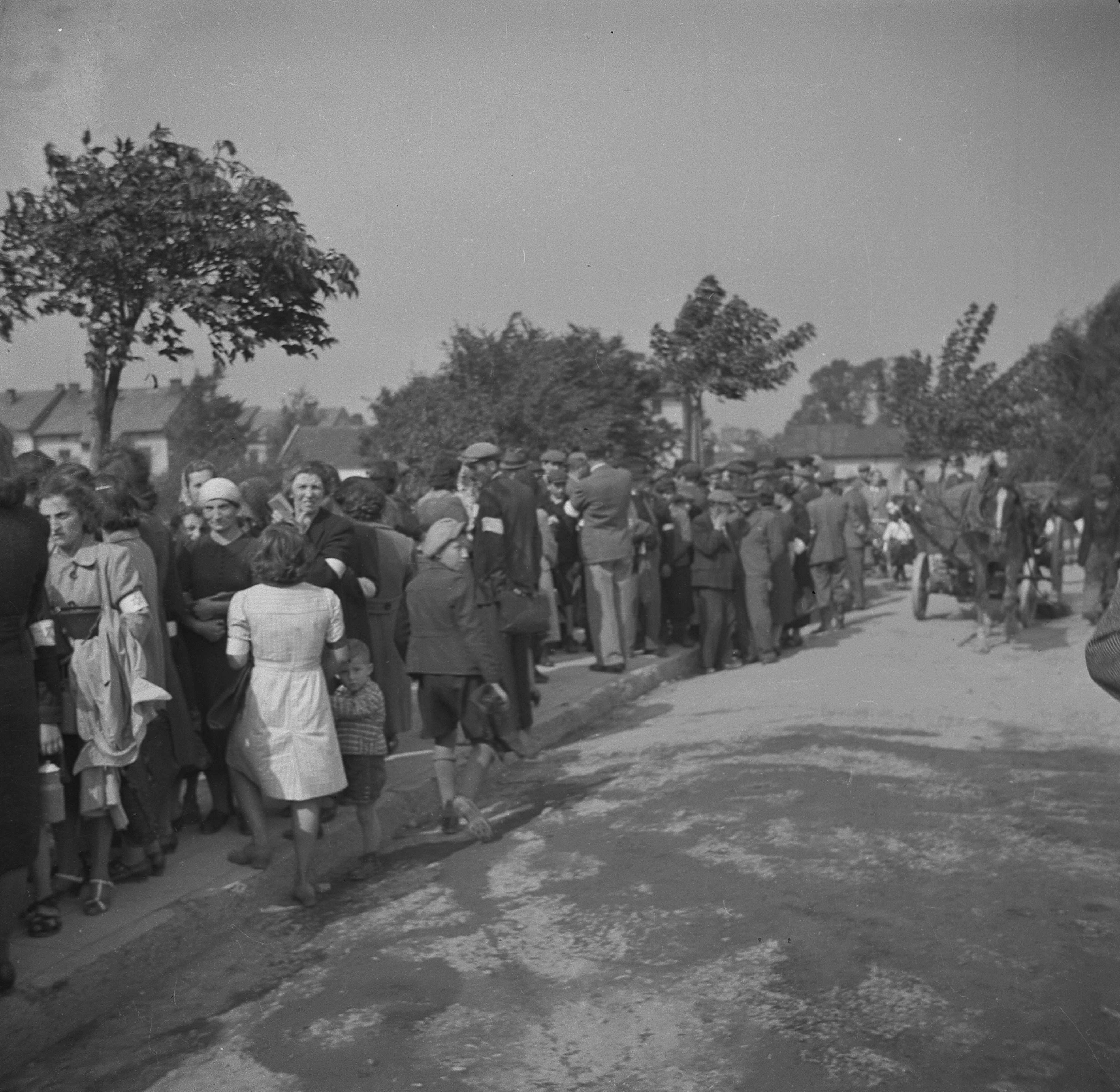 Soldados alemanes vigilan filas de judíos que hacen cola para entrar al centro de la ciudad, recoger racionamientos de comida o pasar algún tipo de registro por parte de las autoridades de la ocupación.