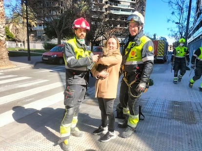 Los bomberos con la dueña del gato tras entregarle el animal, debajo del edificio siniestrado de valencia, en una imagen de X de los bomberos.