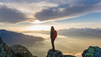 Un viajero contemplando su vida desde lo alto de una montaña.