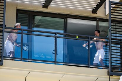 Djokovic pelotea con un acompañante en el balcón de su hotel en Adelaida.