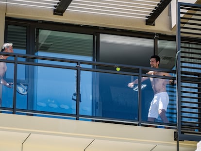 Djokovic pelotea con un acompañante en el balcón de su hotel en Adelaida.
