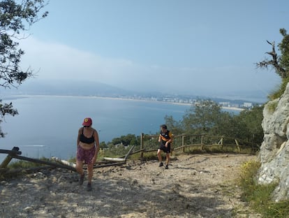 Un hombre y una mujer, en el camino de regreso del faro del Caballo en Santoña.