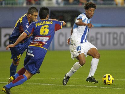 Eliseu busca el pase en la frontal del área ante Ballesteros y Pallardó.