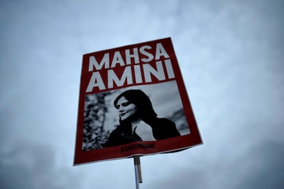 Una mujer iraní muestra una pancarta con la imagen de Masha Amini, la joven muerta a manos de la policía del país por no llevar bien puesto el velo.