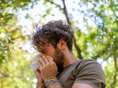 Portrait of a Man with Allergy who is Blowing his Nose, and Coughing and Sneezing. Man with Cold Virus in Nature.