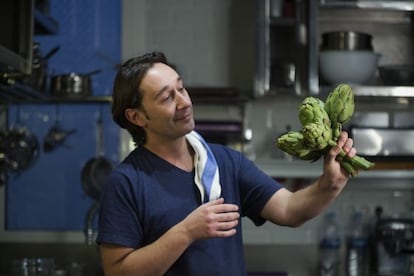 El chef y autor Isma Prados, en la cocina de su casa en pleno romance con unas alcachofas.