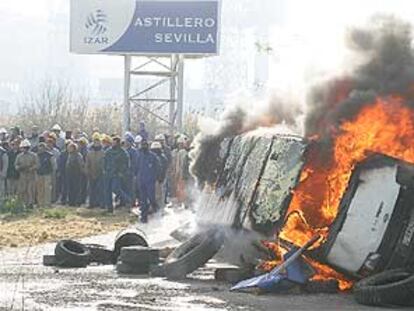 Trabajadores de Izar en Sevilla, junto a una furgoneta y neumáticos ardiendo, durante los enfrentamientos de ayer con la policía.