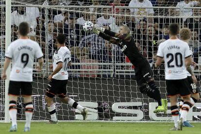 El portero del Valencia, Jaume Doménech, trata de despejar el balón en la jugada que finalmente ha sido el primer gol del Real Madrid.