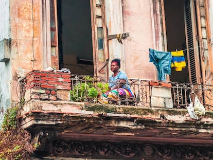 Una mujer en un balcón en La Habana.