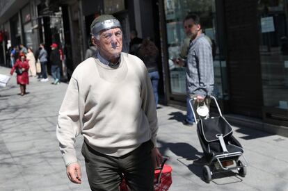 Un hombre camina protegido con una máscara casera, este domingo, en una calle de Madrid. 