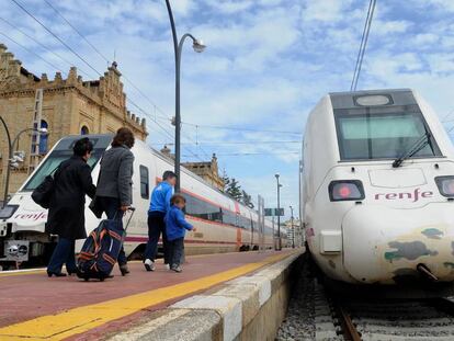 Pasajeros se dirigen a un convoy de Media Distancia de Renfe en la estación de Huelva.