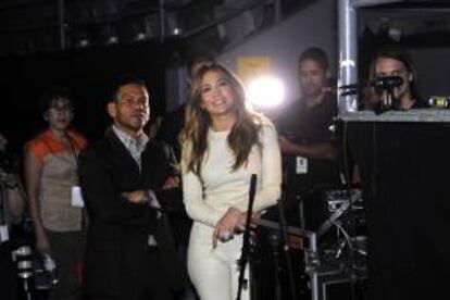La cantante estadounidense Jennifer López (c) ve un video en una pantalla junto a su manager, Benny Medina (izq), durante una rueda de prensa en el Rod Laver Arena de Melbourne (Australia). EFE/Arhivo