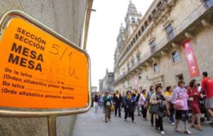 Un grupo de turistas pasa al lado de un colegio electoral en Santiago de Compostela. EFE/Archivo