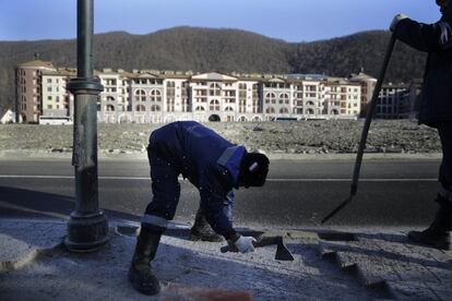 Un trabajador arregla una acera en los alrededores de la villa olímpica de Sochi horas antes de la inauguración de los Juegos de Invierno.