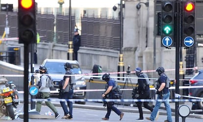 Agentes da policial antiterrorismo atravessam a zona isolada nesta quarta-feira na Ponte de Westminster, em Londres, em proximidade da sede do Parlamento britânico.