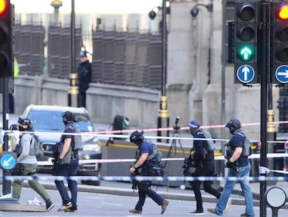 Agentes da policial antiterrorismo atravessam a zona isolada nesta quarta-feira na Ponte de Westminster, em Londres, em proximidade da sede do Parlamento britânico.