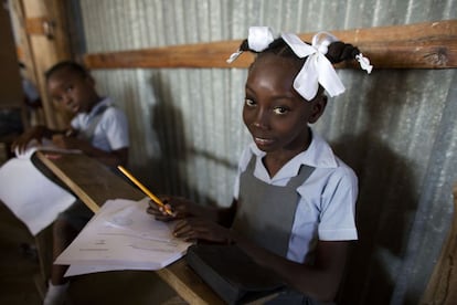 Unas colegialas hacen los deberes en una misión en la Escuela Evangélica de Bethesda en Canaán, Haití. Gran parte del sistema escolar de Haití ha sido privatizado y los habitantes de Canaán no han perdido el tiempo a la hora de construir sus propias escuelas, muchas de ellas por la iglesia. No todos los padres pueden pagar la matrícula o los uniformes de sus hijos para las escuelas. Las que no quieren dar la espalda a los estudiantes más pobres deben luchar para encontrar fuentes adicionales de financiación.