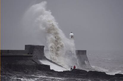 Olas rompren sobre el faro en Porthcawl (Gales).