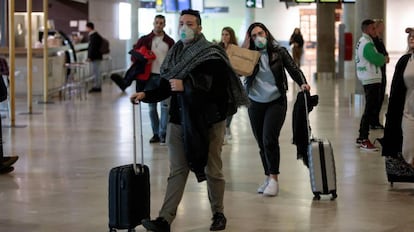 Viajeros procedentes de Italia protegidos con mascarillas a su llegada al aeropuerto de Manises (Valencia).