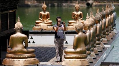 Una turista fotografía estatuas de Buda en un templo de Colombo, capital de Sri Lanka.