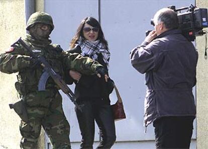 Un policía dialoga en Belgrado con un equipo de televisión junto a la casa de la viuda de Arkan.