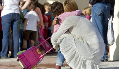 Una mare s'acomiada de la seva filla, el primer dia de classes.