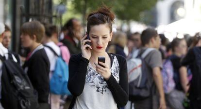 Una joven con dos m&oacute;viles en la calle Arenal de Madrid. 