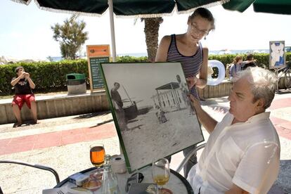 Yvonnette, hija del poeta Carlos Barral, le muestra a Juan Marsé una fotografía de la infancia de su padre en Calafell (Tarragona), en 2008.