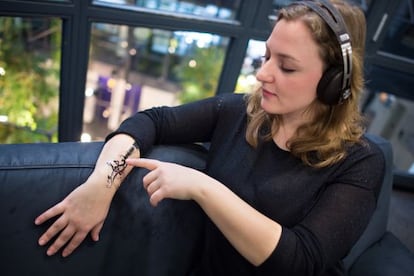 Una mujer usa el nuevo sensor que permite utilizar los dispositivos móviles tocando la piel.