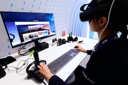 Una mujer utiliza un ordenador y unas gafas de realidad virtual en la última edición del Mobile World Congress celebrado en Barcelona.