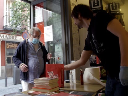 Gonzalo Queipo, fundador de Tipos Infames, atiende a dos clientes en el mostrador que han situado a pie de calle.