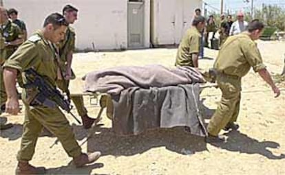 Soldados israelíes trasladan el cadáver del militante de Hamás Abdel Karim Maname, muerto ayer en la franja de Gaza.