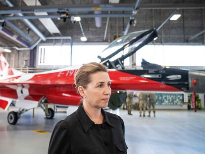La primera ministra danesa, Mette Frederiksen, junto a un caza F-16, este jueves en Vojens (Dinamarca).