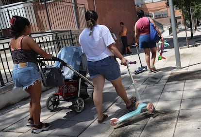 Varias personas se protege en la sombra durante la ola de calor del mes de julio, en San Cristóbal de los Ángeles, Madrid. 