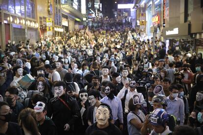 Una multitud de personas con caretas concentradas en una calle de Hong Kong, en una marcha en desafío a la prohibición del Gobierno de usar máscaras. 
