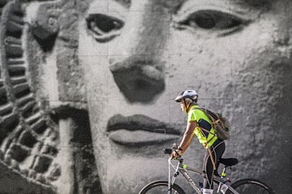 Ciclista delante de un vitromosaico con la imagen de la Dama de Elche en la plaza del Parque. 
