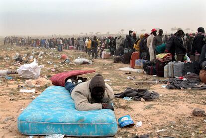 Refugiados ganeses que huyeron de Libia se disponen a subir a un autobús para abandonar el campamento levantado cerca de Ras Jdir, Túnez, hoy, martes 15 marzo de 2011. Unos 215.000 trabajadores emigrantes de diversas nacionalidades han abandonado ya Libia desde el comienzo de la crisis el 20 de febrero, de acuerdo con los datos de la ONU, que espera que otros 400.000 salgan del país para huir de los combates entre las fuerzas del dictador Muamar Gadafi y la resistencia.